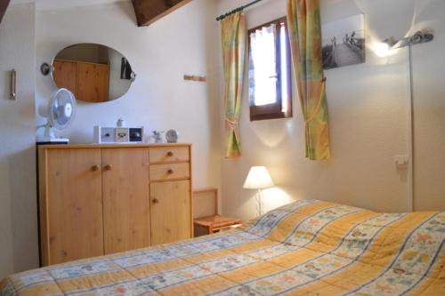 une chambre avec un lit, une commode et un miroir dans l'établissement SP570-70L Mais 2 pièces mezzanine SAINT PIERRE LA MER, à Saint Pierre La Mer