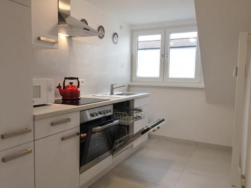 a white kitchen with a stove and a sink at Ferienwohnung Kreuder in Bergisch Gladbach