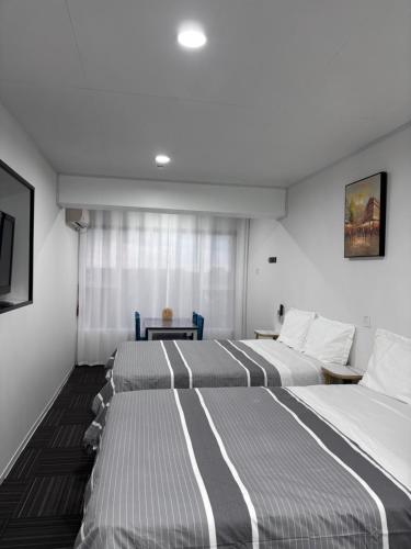 a hotel room with two beds and a table at Amber Lake B in Auckland