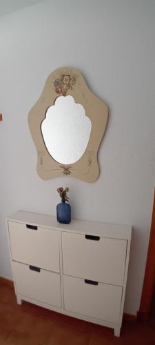 un comò bianco con uno specchio sul muro di Eki a Conil de la Frontera