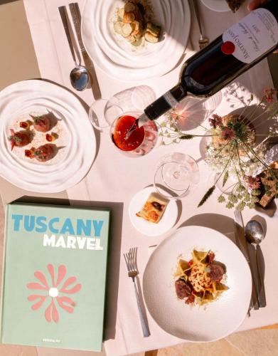 a table with plates of food and a bottle of wine at Mastrojanni Relais in Montalcino