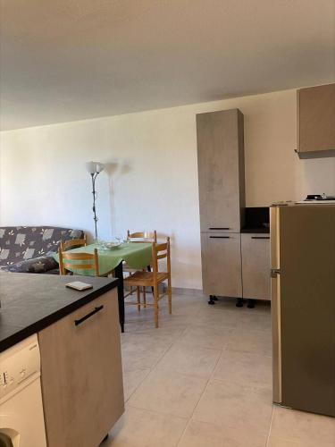 une cuisine et une salle à manger avec une table et un réfrigérateur dans l'établissement SP520-J233 Appt 2 pièces SAINT PIERRE LA MER, à Saint Pierre La Mer