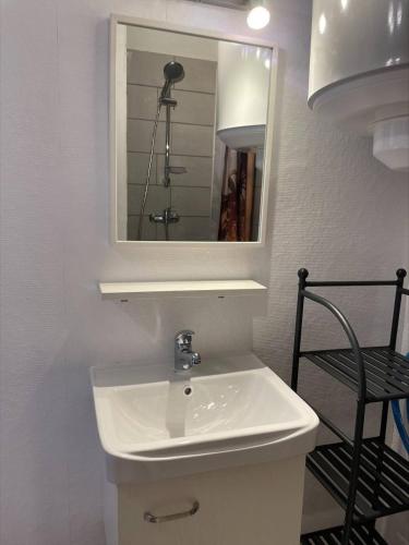 une salle de bain avec un lavabo blanc et un miroir dans l'établissement SP520-J233 Appt 2 pièces SAINT PIERRE LA MER, à Saint Pierre La Mer