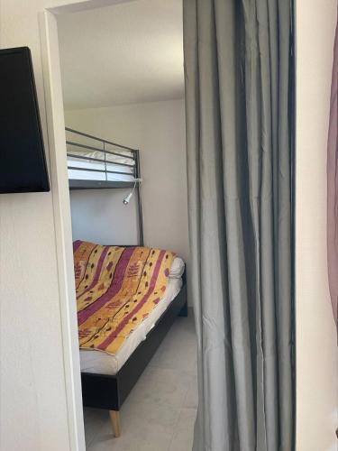 - une chambre avec des lits superposés et un rideau dans l'établissement SP520-J233 Appt 2 pièces SAINT PIERRE LA MER, à Saint Pierre La Mer