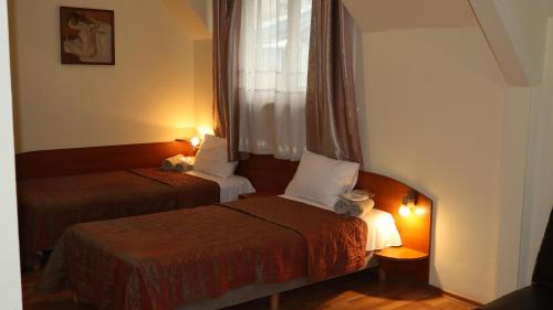 a hotel room with two beds and a window at Hotel Palitra in Varna City