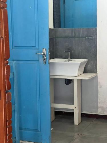 a bathroom with a sink and a blue door at Light House Residence in Dondra West