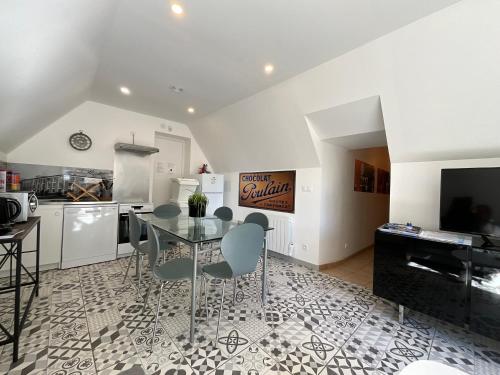 une salle à manger avec une table en verre et une cuisine dans l'établissement Appartement 