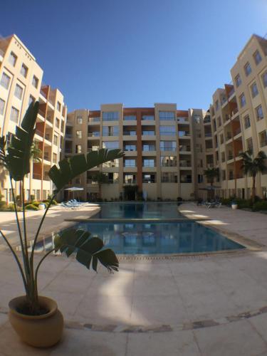 a plant in a pot in front of a building at Rivoli Suites in Hurghada