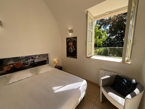 a bedroom with a bed and a window and a chair at Appartement "Poulain" en Centre-ville linge inclus in Blois