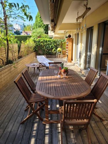une table et des chaises en bois sur une terrasse dans l'établissement Le Bijou de Valrose - 4 Bedroom with Pool, à Nice
