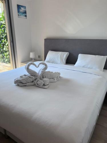 - un lit avec 2 serviettes en forme de cœur dans l'établissement Le Bijou de Valrose - 4 Bedroom with Pool, à Nice