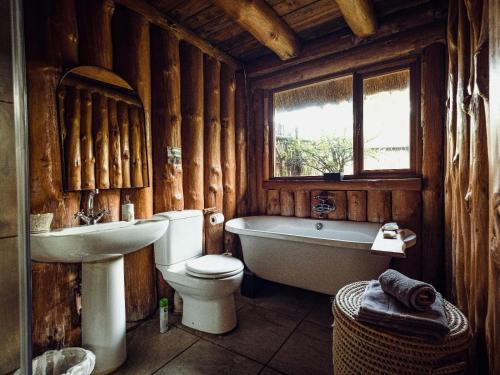 a bathroom with a tub and a toilet and a sink at Rhino River Lodge in Manyoni Private Game Reserve