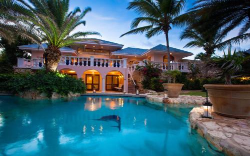 a swimming pool in front of a house with a shark in the water at Luxury Villa in George Hill