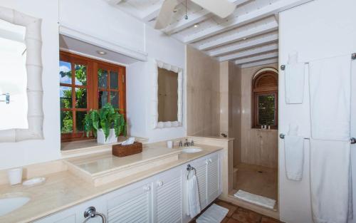 a white bathroom with a sink and a mirror at Luxury Villa in George Hill