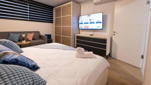a bedroom with a bed and a flat screen tv at O&O Group - The SeaGate Estate suites - Suite 1 in Rishon LeẔiyyon