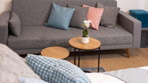 a living room with a couch and a table with flowers on it at O&O Group - The SeaGate Estate suites - Suite 1 in Rishon LeẔiyyon