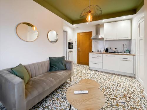 un salon avec un canapé et une cuisine dans l'établissement Le Joly - Centre Ville - Proche Gare - Rennes, à Rennes