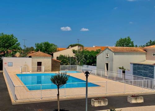 une piscine entourée d'une clôture dans l'établissement Mais 2 pièces mezza CHATELAILLON PLAGE - CL080-022, à Châtelaillon-Plage
