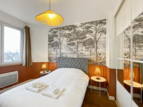 une chambre avec un lit avec deux serviettes dessus dans l'établissement Le Joly - Centre Ville - Proche Gare - Rennes, à Rennes