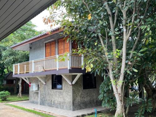 a house with a balcony on the side of it at Rublom Resort Mae Taeng in Ban Pak Thang