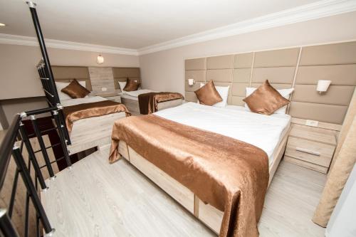 a hotel room with three beds and a staircase at Passage Hotel in Baku