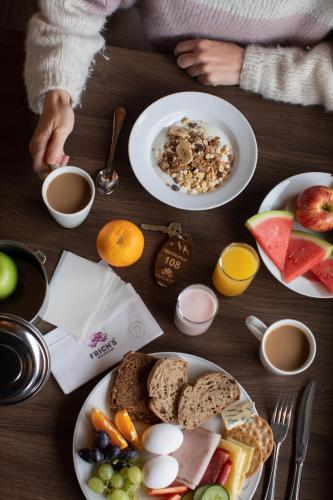 een tafel met borden ontbijtproducten erop bij Basecamp Frich`s Hjerkinn in Hjerkinn