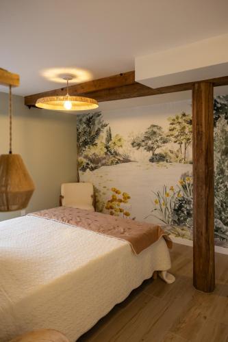 une chambre avec un lit avec un tableau sur le mur dans l'établissement Moulin Lèves-Chartres-Un air de campagne, à Lèves