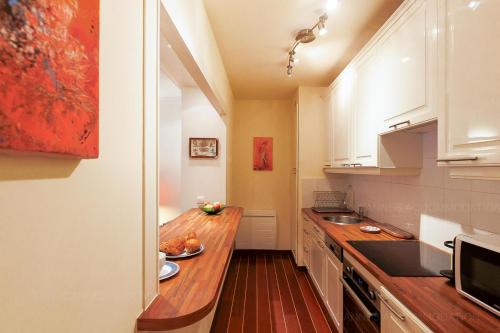 une cuisine avec des armoires blanches et un comptoir en bois dans l'établissement Gray 2A2, à Cannes