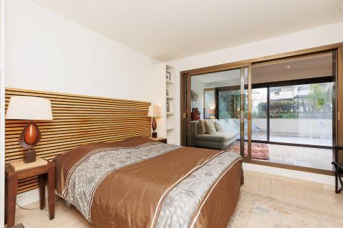 une chambre avec un grand lit et une grande fenêtre dans l'établissement Gray 2A2, à Cannes