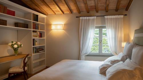 a bedroom with a bed and a window and a desk at Dimora Ghirlandaio in Impruneta