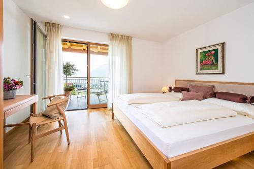 a bedroom with two beds and a desk and a chair at Unterpenatz Schenna in Schenna
