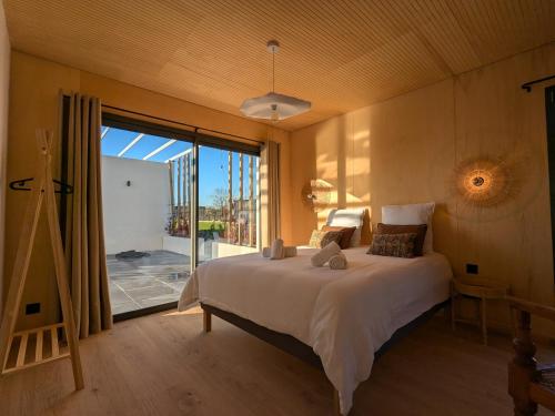 a bedroom with a large bed and a large window at Maisons du lac in Écollemont