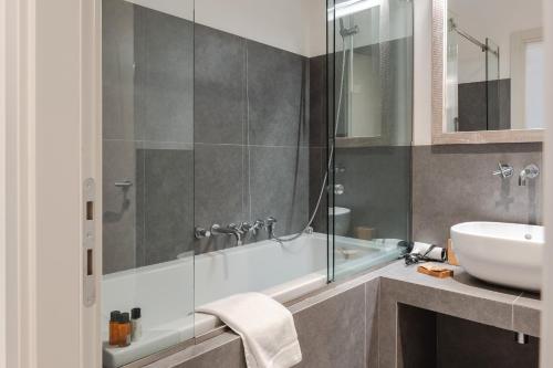 a bathroom with a bath tub and a sink at Borgo Syrah in Cortona