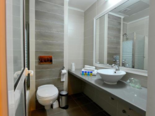 a bathroom with a white toilet and a sink at Astoria Galilee Hotel in Tiberias