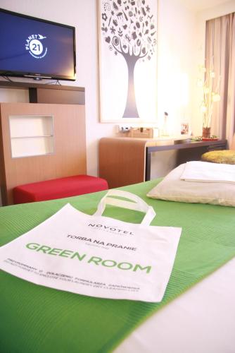 a hotel room with a green room sign on a table at Novotel Warszawa Airport in Warsaw