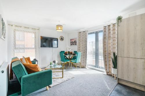 a living room with a green couch and a table at Affordable 1 & 2 Bed Apartments in Slough, Great Heathrow Location in Colnbrook