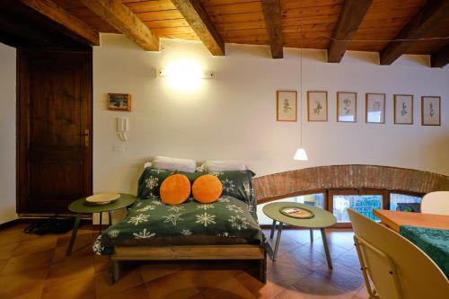 a living room with a couch with two orange pillows at Casa Del Borgo Valpolicella in San Pietro in Cariano