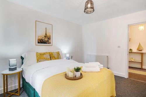 a bedroom with a bed and a table with towels at Affordable 1 & 2 Bed Apartments in Slough, Great Heathrow Location in Colnbrook