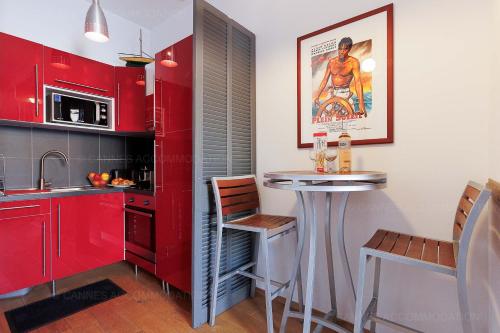 une cuisine avec des placards rouges et un petit bar dans l'établissement Cruise, à Cannes