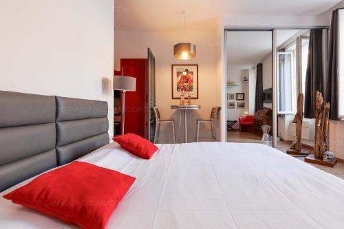een slaapkamer met een groot bed met rode kussens erop bij Cruise in Cannes