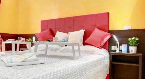 Schlafzimmer mit einem Bett mit rotem Kopfteil in der Unterkunft Termini Suites in Rom