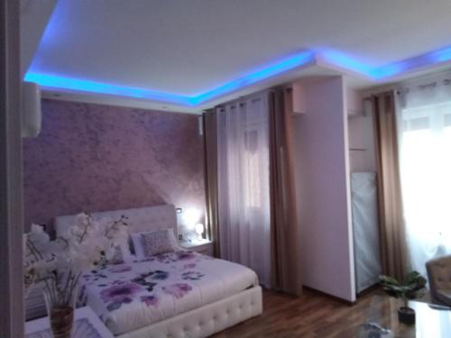 a bedroom with a bed with a blue light on the ceiling at Katrin luxury in Verona