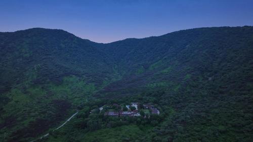 an aerial view of a house in the middle of a mountain at Anandam - A Luxury Resort in Udaipur in Udaipur