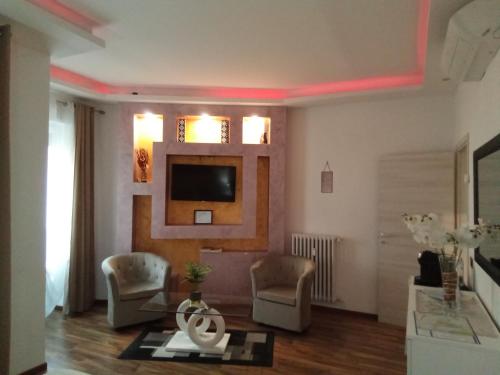 a living room with two chairs and a tv on the wall at Katrin luxury in Verona