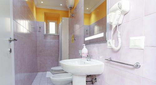 ein Bad mit einem Waschbecken, einem WC und einem Telefon in der Unterkunft Termini Suites in Rom