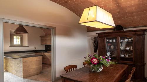 a kitchen with a table with a vase of flowers on it at Dimora Ghirlandaio in Impruneta