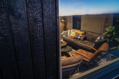 a reflection of a living room with a leather couch at Black diamond villa in Mosfellsbær
