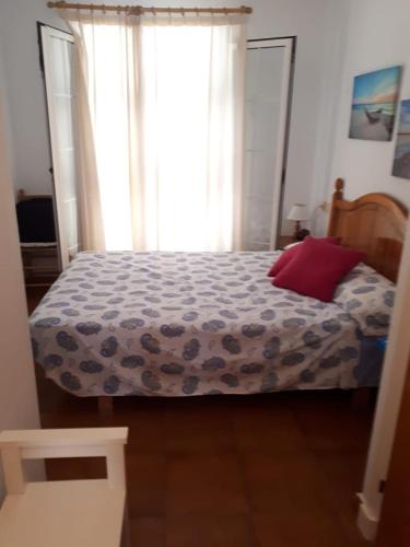 a bedroom with a bed with a red pillow on it at Costa Arenal 81 in Arenal d'en Castell