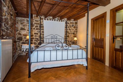 a bedroom with a metal bed in a stone wall at Casa de Ligueria in Rozapanera