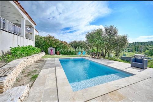 une piscine devant une maison dans l'établissement belle maison de vacances climatisée,3ch avec piscine, à Nîmes